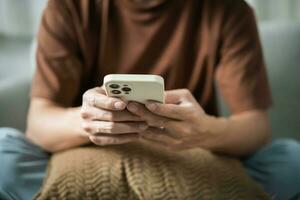 relaxado jovem ásia homem usando inteligente telefone gastos Tempo verificação notícia social meios de comunicação foto