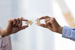 empresários mãos conectando o quebra-cabeça. conceito de trabalho em equipe de negócios. foto