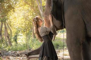 linda mulher asiática e elefante na natureza foto