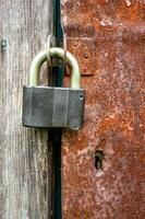 uma pesado cadeado em uma oxidado metal porta. foto