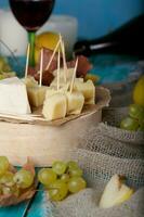 queijo fatias, pera, e uvas em uma de madeira ficar em pé. foto