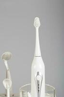 ultrassônico escova de dente kit em uma cinzento fundo. foto