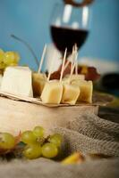 queijo fatias, pera, e uvas em uma de madeira ficar em pé. foto