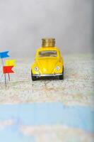 mini carro, colorida alfinetes, moedas em uma mapa. foto