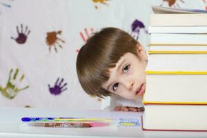 Garoto do Sete anos velho com livros. costas para escola foto