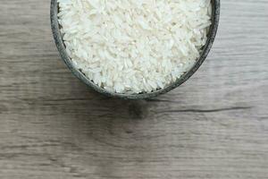 branco arroz, arroz dentro a ferro recipiente em a de madeira fundo foto