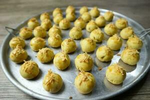 Nastar keju. caseiro abacaxi azedo ou Nastar keju, biscoitos com abacaxi geléia preenchidas e espalhar Grato queijo em a alumínio frigideira, fresco a partir de a forno. servido durante eid al fitri foto