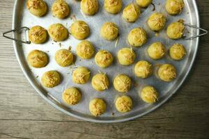 Nastar keju. caseiro abacaxi azedo ou Nastar keju, biscoitos com abacaxi geléia preenchidas e espalhar Grato queijo em a alumínio frigideira, fresco a partir de a forno. servido durante eid al fitri foto