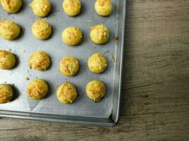 Nastar keju. caseiro abacaxi azedo ou Nastar keju, biscoitos com abacaxi geléia preenchidas e espalhar Grato queijo em a alumínio frigideira, fresco a partir de a forno. servido durante eid al fitri foto