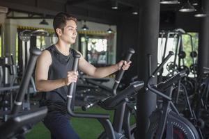 homem bonito correndo em uma esteira em uma academia foto