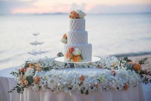 bolo de casamento ao pôr do sol na praia casamento foto