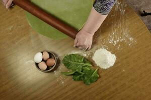 da vovó mãos amassar, massa para verde Macarrão. foto