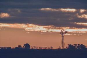 panorama com moinho de vento às pôr do sol, pampas, Patagônia, Argentina foto