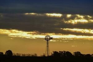 panorama com moinho de vento às pôr do sol, pampas, Patagônia, Argentina foto