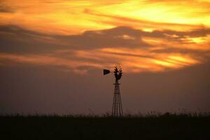 rural panorama com moinho de vento às pôr do sol, pampas , Argentina foto