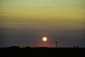 moinho de vento dentro campo às pôr do sol, pampas, Patagônia, Argentina. foto