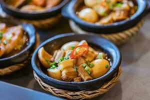 ovos ensopado com barriga carne de porco chinês Comida em argila Panela foto