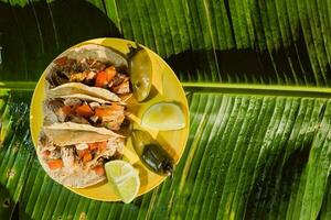 a mexicano carnitas tacos, coberto com verde ingredientes, estão uma grampo Comida dentro mexicano cozinha foto