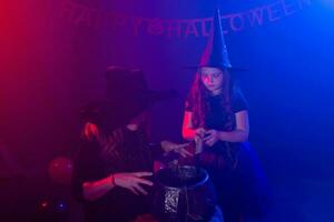 engraçado criança menina e mulher dentro bruxas fantasias para dia das Bruxas com abóbora jack foto