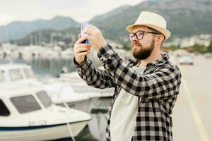 viajante homem levando As fotos do luxo iates marinho durante ensolarado dia - viagem e verão conceito