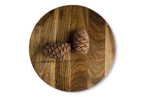 uma velha tábua de cortar de madeira desfiada com cones de cedro, isolada em um fundo branco. close-up texturizado, vista superior foto