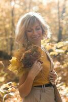 retrato do lindo jovem mulher caminhando ao ar livre dentro outono. outono estação e à moda menina conceito. foto
