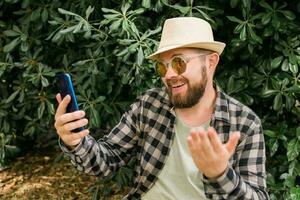 barbudo homem fazendo vídeo ligar em Smartphone ao ar livre - vídeo conexão e tecnologias conceito foto