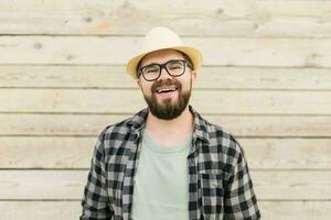 rindo atraente homem vestindo chapéu sobre de madeira fundo - emoção e período de férias viagem feriados conceito foto