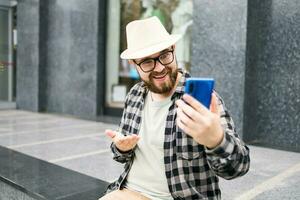 barbudo homem fazendo vídeo ligar em Smartphone ao ar livre - vídeo conexão e tecnologias conceito foto