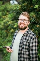 rindo atraente homem vestindo chapéu sobre verde árvore fundo - emoção e período de férias viagem feriados conceito foto