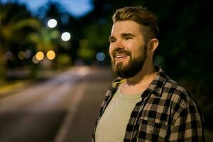 retrato do homem em pé dentro noite cidade rua com cópia de espaço e Lugar, colocar para texto. confiante feliz cara. fechar-se retrato foto