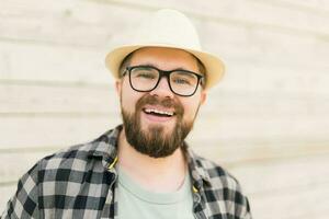 rindo atraente homem vestindo chapéu sobre de madeira fundo - emoção e período de férias viagem feriados conceito foto