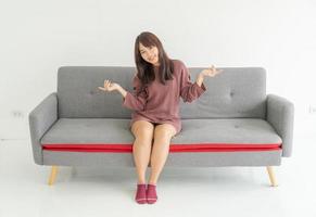 mulher asiática no sofá da sala com espaço de cópia