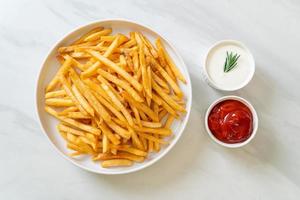 batatas fritas com creme de leite e ketchup foto