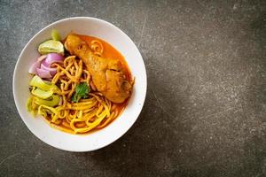 Sopa de macarrão ao curry do norte da Tailândia com frango - kao soi kai - comida tailandesa foto