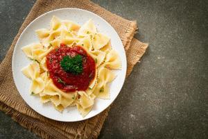 macarrão farfalle em molho de tomate com salsa - comida italiana foto