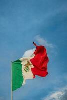 a mexicano bandeira sobe Alto contra a céu, simbolizando nacional orgulho durante a evento. foto