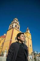 uma homem capturando uma selfie dentro frente do uma lindo Igreja dentro guanajuato, México foto
