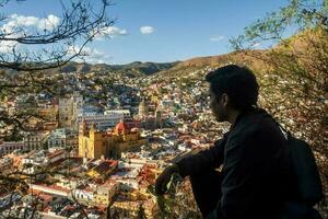 uma homem desfrutando a vibrante paisagem urbana do guanajuato, México, cercado de natureza e icônico marcos foto