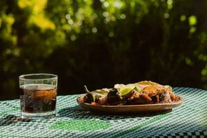 a mexicano carnitas, uma delicioso comida, é servido com vários condimentos em uma mesa com talheres foto