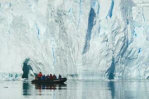 turistas observando uma geleira em a Antártica, paraíso baía, antártico Península. foto
