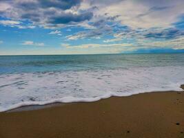 lindo Visão do a de praia e a mar dentro a cedo manhã foto