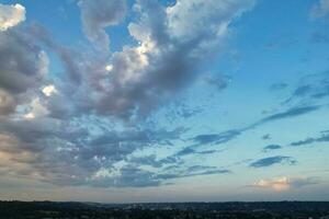 Alto ângulo Visão do luton cidade do Inglaterra durante nascer do sol com dramático nuvens sobre azul céu. imagem estava capturado com drones Câmera em Julho 8º, 2023 foto