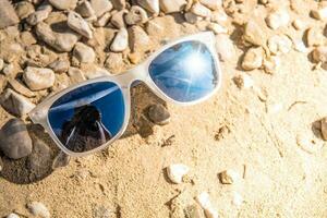 oculos de sol em rochoso de praia foto