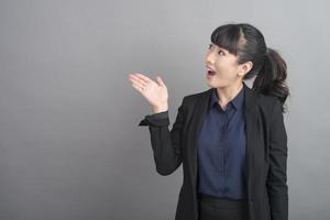 Mulher de negócios sorridente com blazer em fundo cinza foto