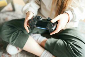 pequeno menina jogando em jogos console foto