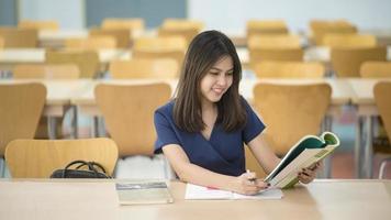 belas mulheres universitárias asiáticas na biblioteca foto