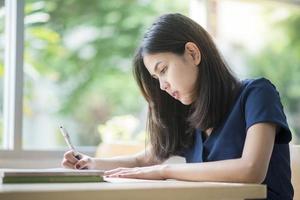 belas mulheres universitárias asiáticas na biblioteca foto