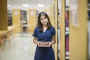 belas mulheres universitárias asiáticas na biblioteca foto
