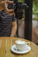 fotógrafo tirando foto de xícara de café em cafeteria